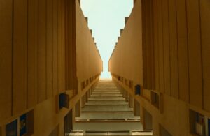 A staircase rising between two parallel walls toward an open sky, representing the steady, upward path of financial planning for HENRYs