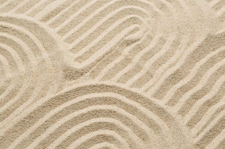 A calming texture of raked sand in a Zen garden, symbolizing structure, intentionality, and control for a wealth management article.
